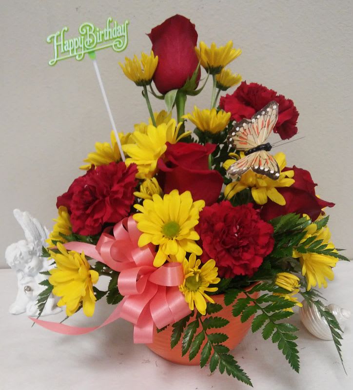 Red roses,yellow daisies, red carnations and a butterfly brightens up the &quot;Happy
