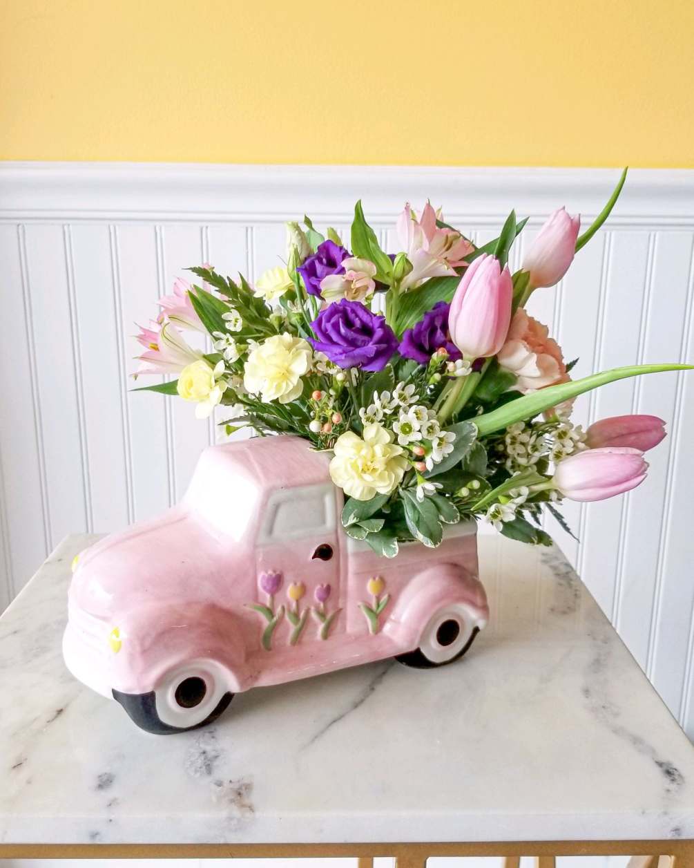 Pink ceramic pick up truck with tulips and complimentary purple and yellow