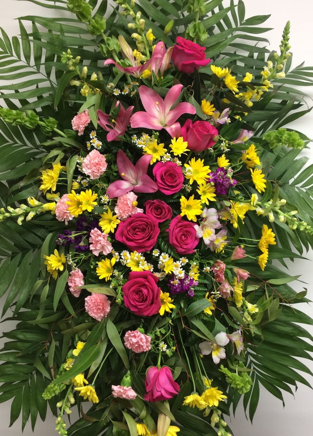 Pink lilies, pink roses &amp; carnations, daisy accents, and yellows.