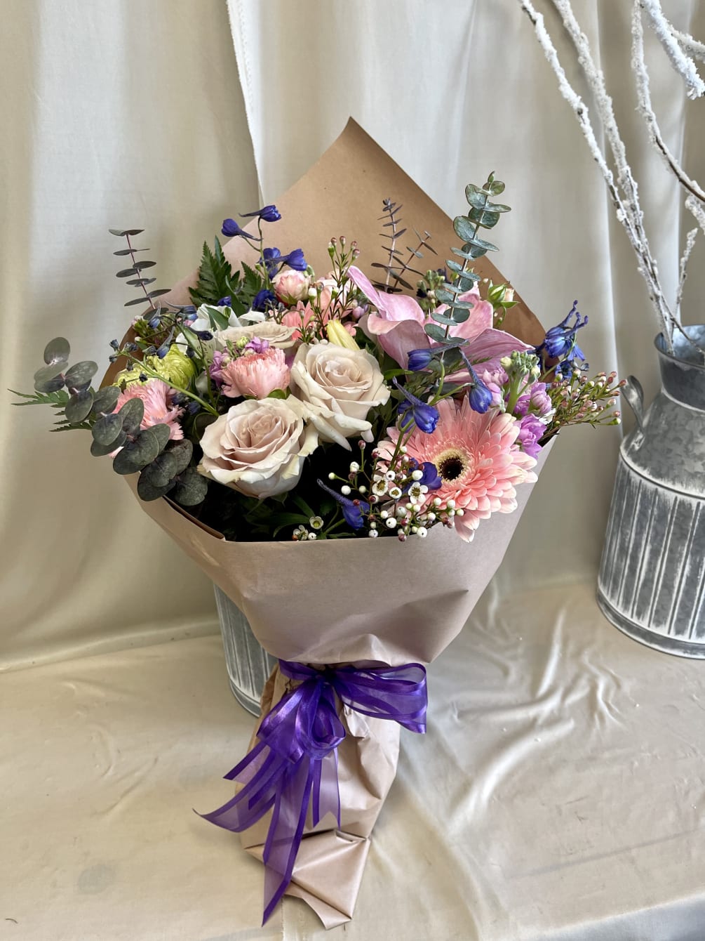 Mix of beautiful premium light colored flowers wrapped. Base included under wrapping