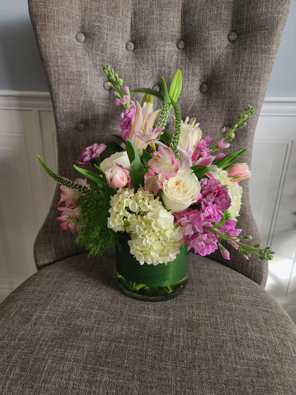 In a glass leaf lines cylinder, pastel blooms offer spring textures and