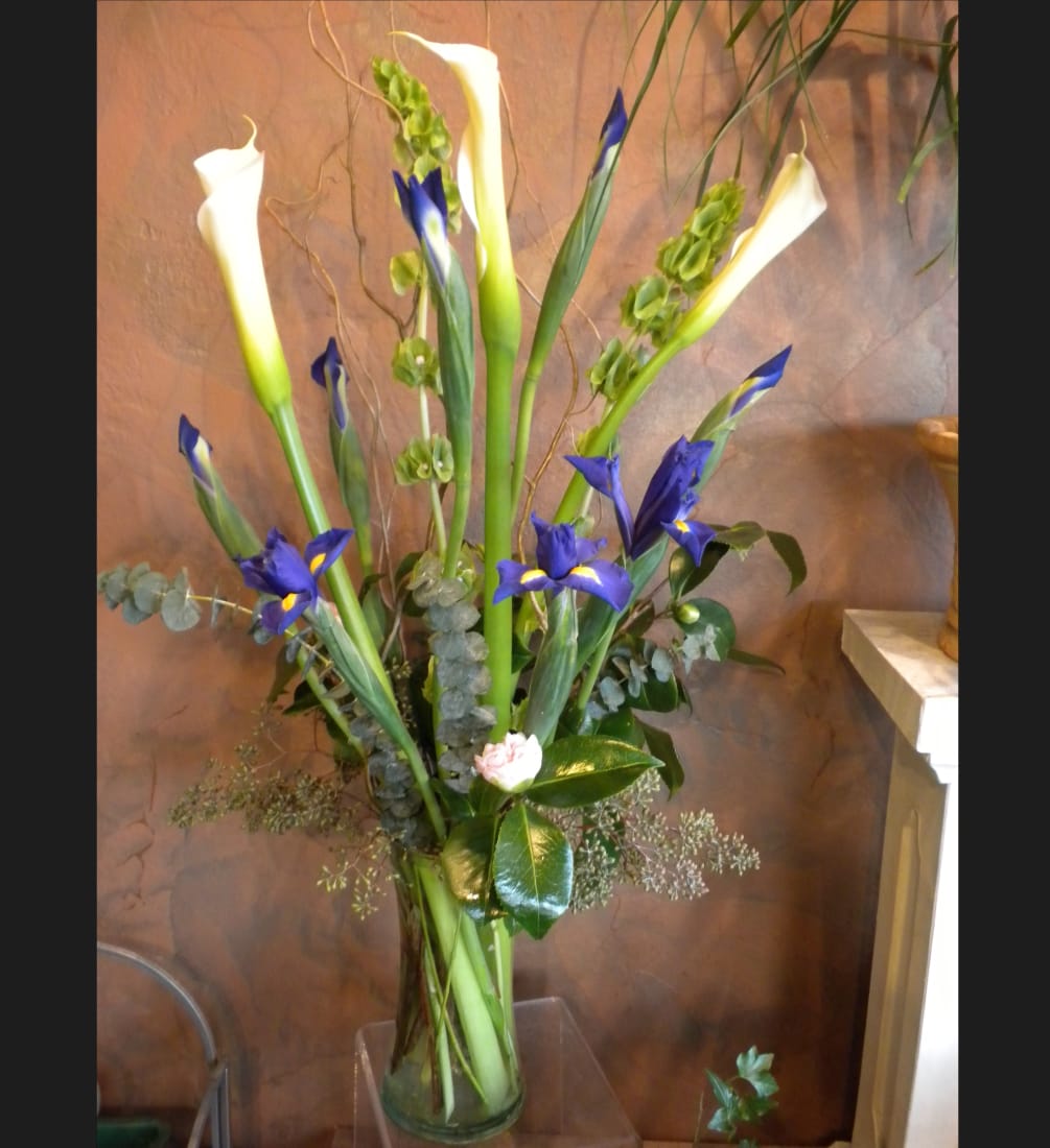 Tall and simple contemporary vase arrangement. Calla Lilies, Bells of Ireland and