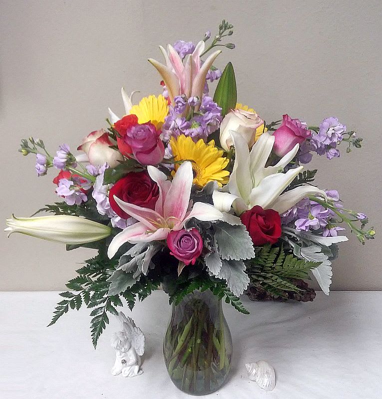 Bouquet contains an assortment of stock, roses, lilies, gerbera daisies, dusty miller.