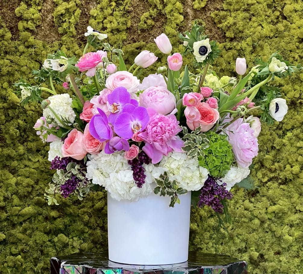 This elegant and posh garden arrangement sits regally in a beautiful white