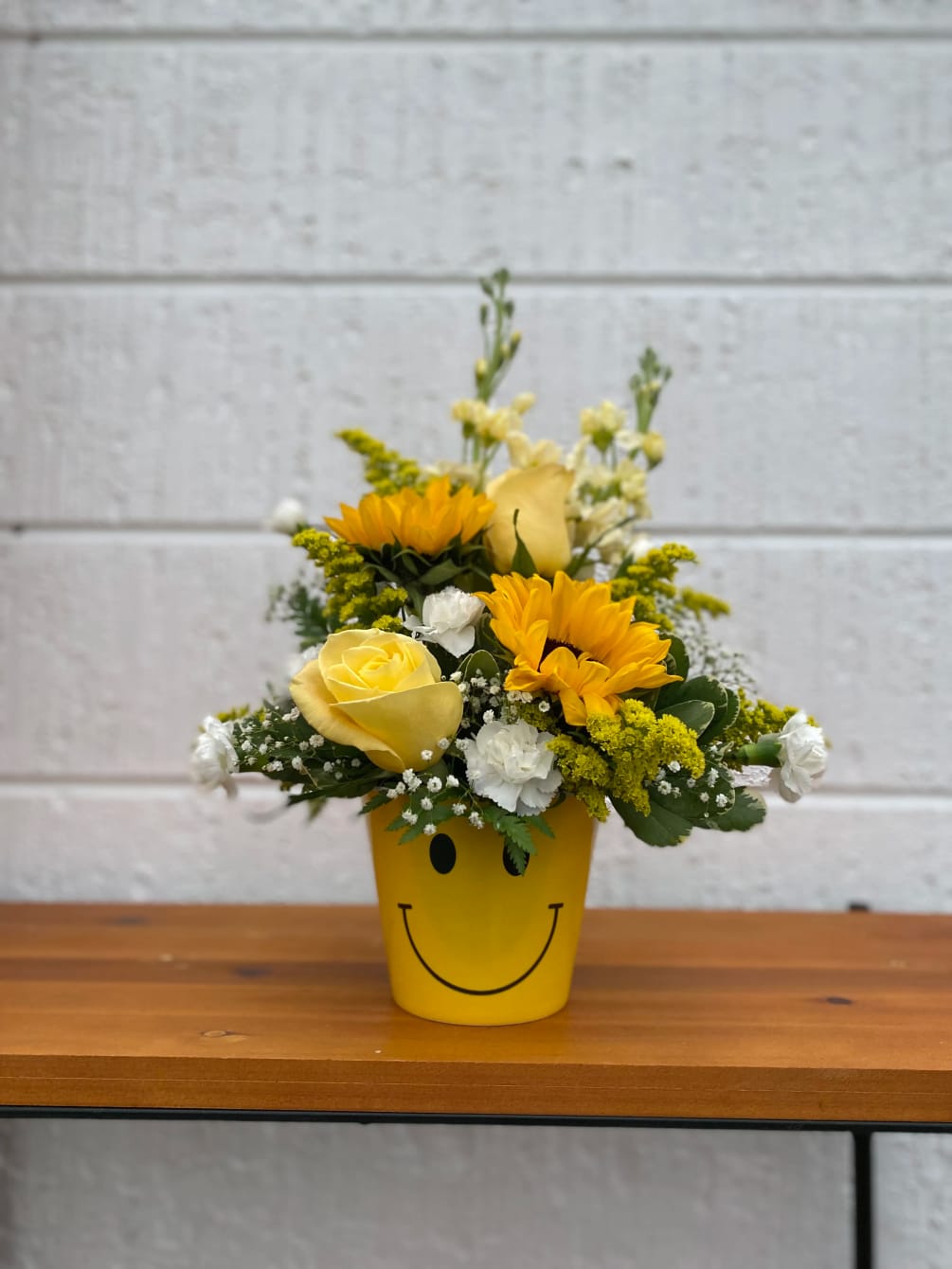 A cheery mix of bright, colorful flowers in a Smiley Container!
Just the
