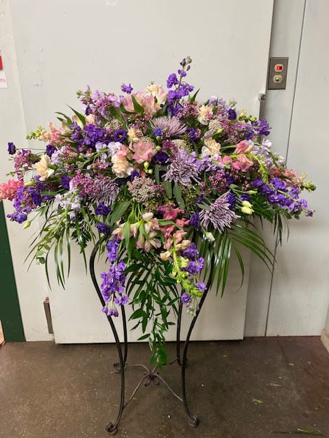 Purple stock, lavendar and pink roses with carnations and fillers make this