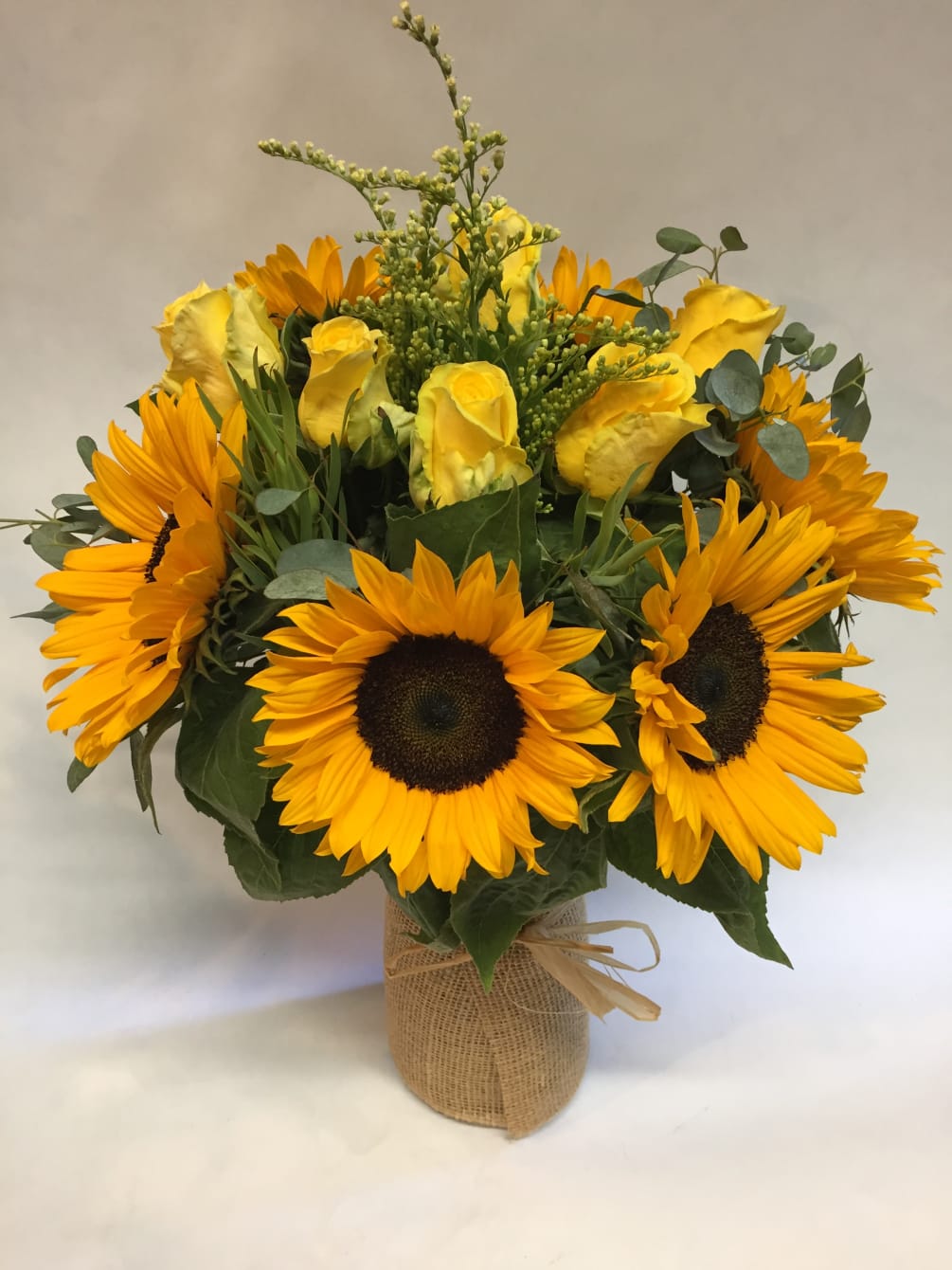 This bright and sunny arrangement comes complete with sunflowers, solidago, yellow roses