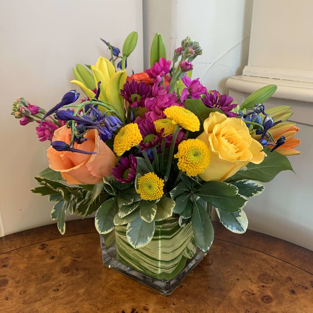 yellow, apricot and orange roses with blue delphinium, magenta stock, yellow buttons