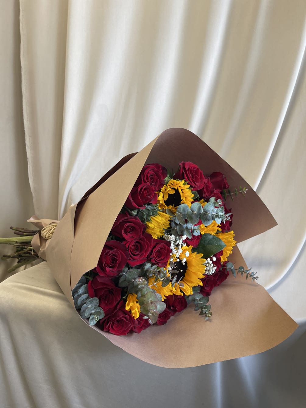 2 dozen roses and touches of sunflowers with rustic wrapping