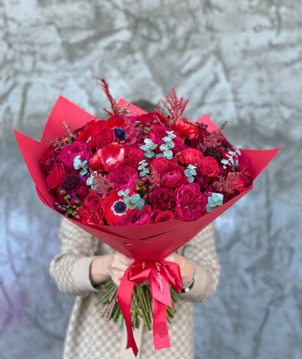 Fantastic bouquet in red shades, filled with Anemones, Roses, Carnations, Eucalyptus and
