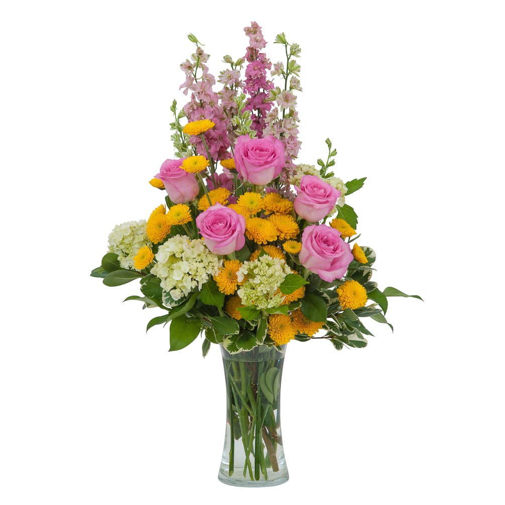A garden style arrangement arranged in a beautiful clear glass vase to