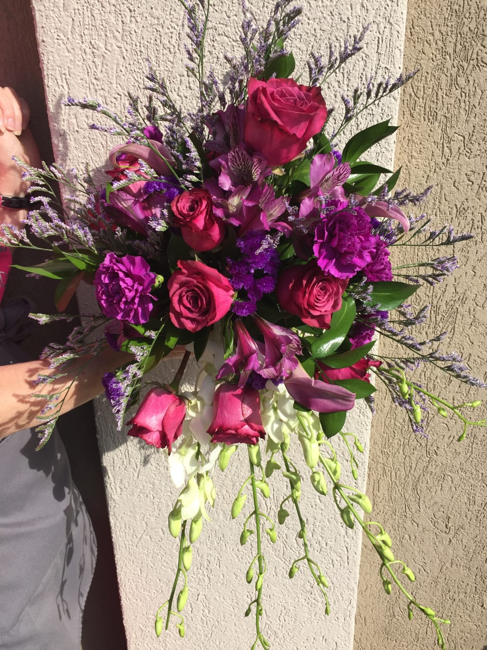 Deep purple roses, white orchids, fushia carnations and purple alsto 