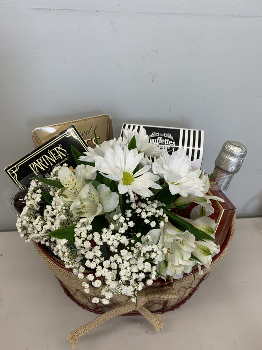 Red basket with goodies and flower arrangement 