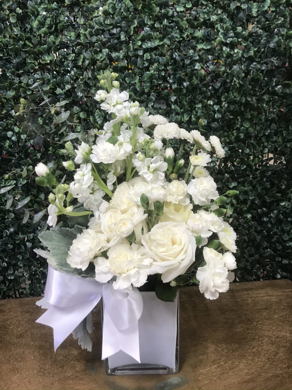 All white flowers gracefully arranged in a white cube to give peace