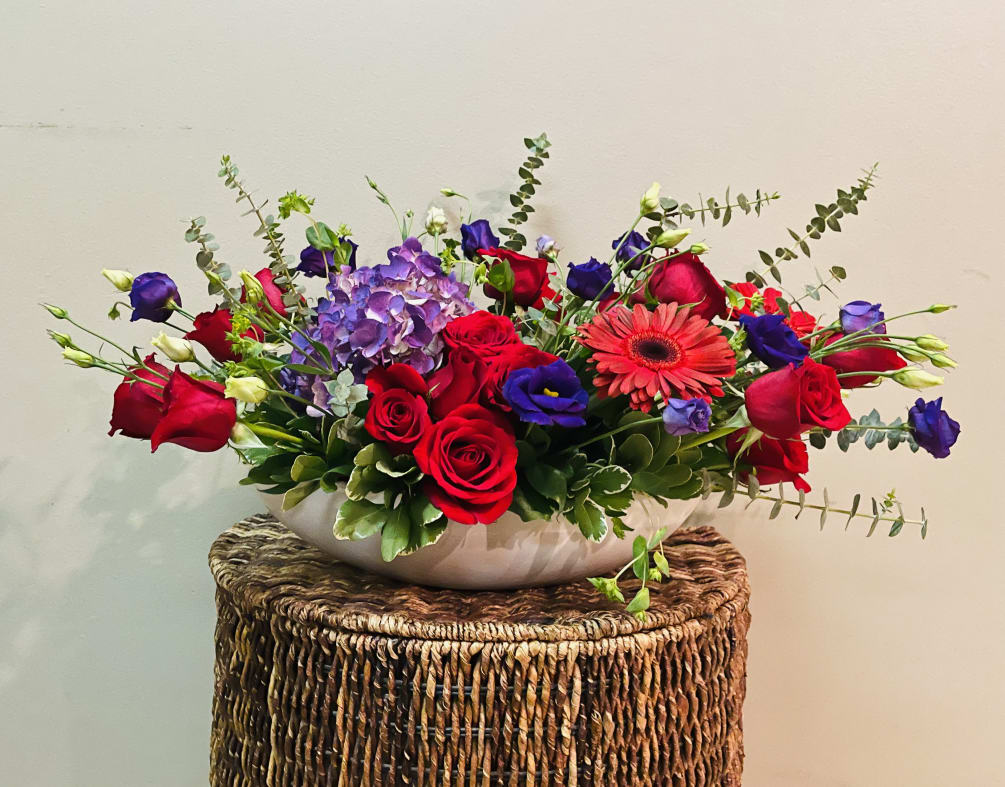 18 Red roses mixed with purple flowers and lots of greens in