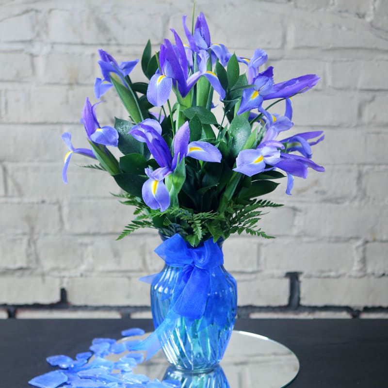 An intoxicating arrangement of blue iris, styled in a matching blue glass