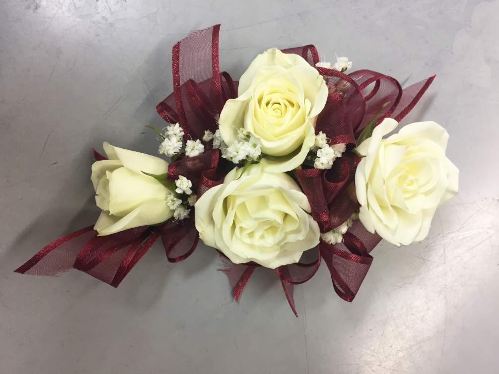 Four spray rose wrist corsage with a fancy ribbon and baby&#039;s breath.