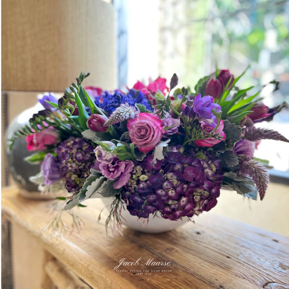 A gorgeous mix of purple and lavender seasonal flowers on a white