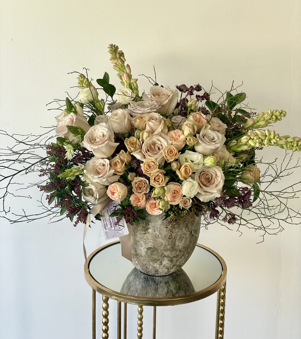 Beautiful blush roses, spray roses, fragrant tub-rose, and lush greens arranged with