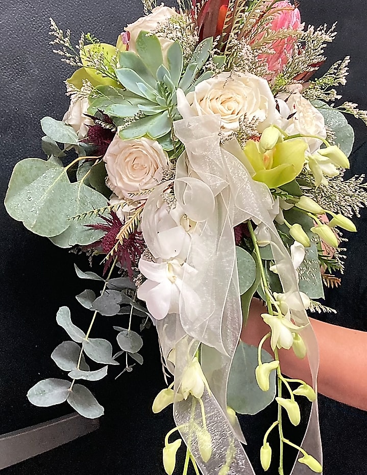 ORCHIDS, ROSES, SUCCULENTS AND OTHER CAPE FLORA ADORN THIS BRIDAL BOUQUET.