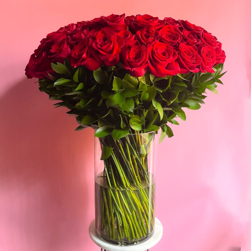 This stunning flower arrangement features 75 premium long stem red roses beautifully