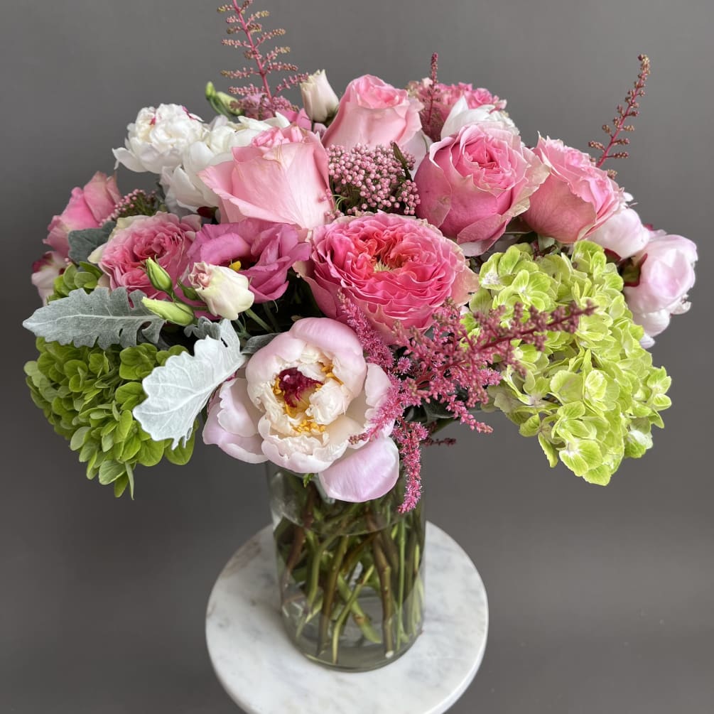 An exquisite floral arrangement in a clear cylinder vase boast an opulent