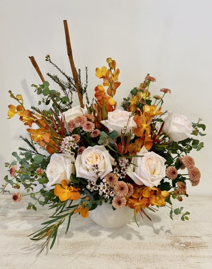 A Mix of Amber orchids and white scented garden roses in a