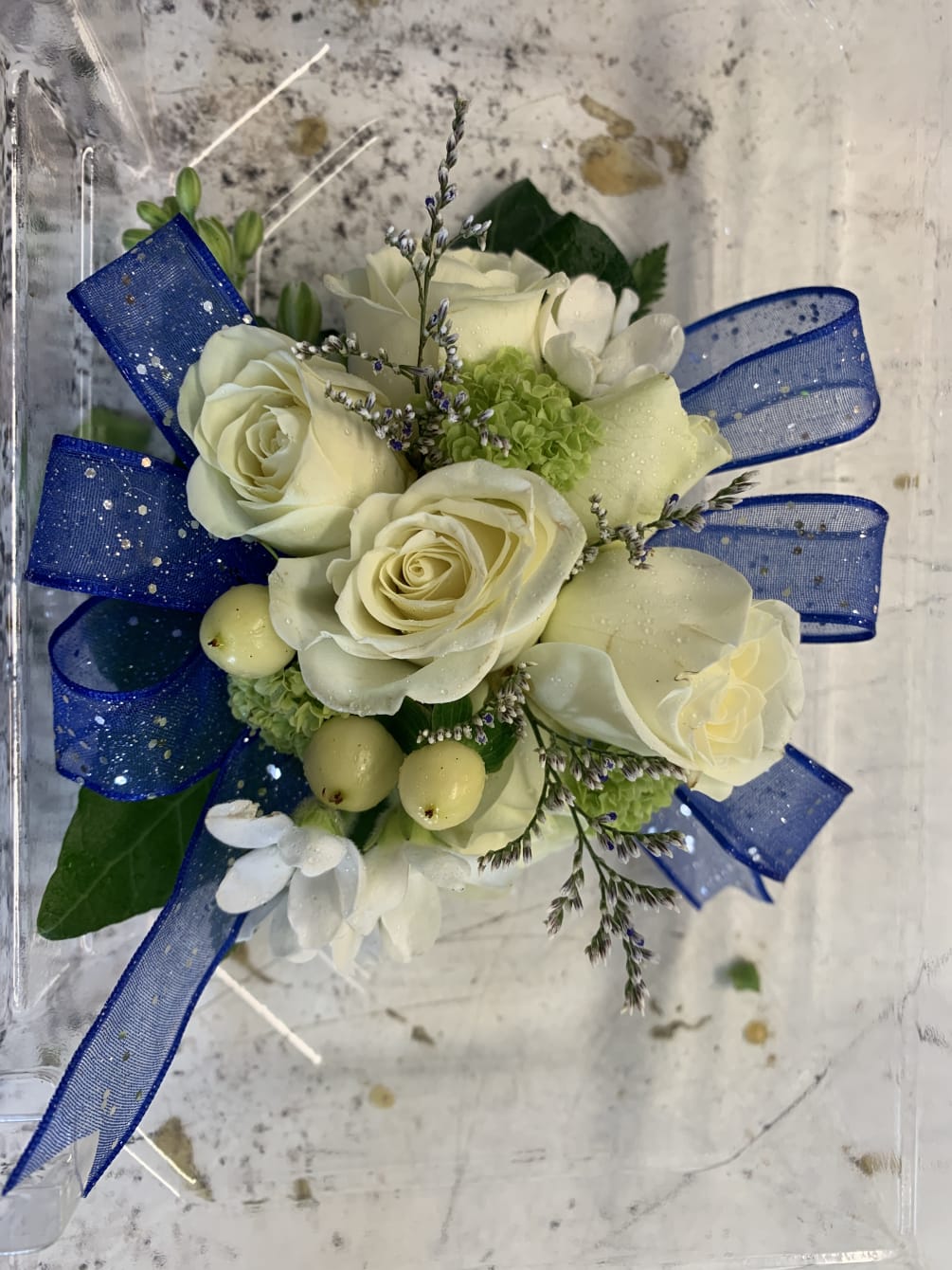 A classic corsage with colored ribbon to match the dress.  Please