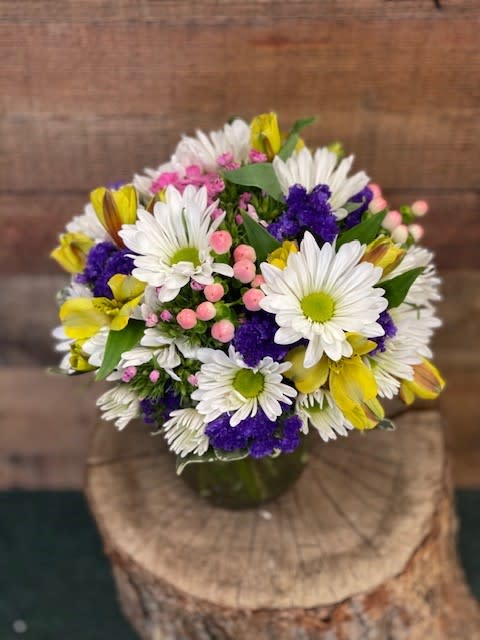 Vibrant white daisies accented with colorful long lasting blooms will brighten any
