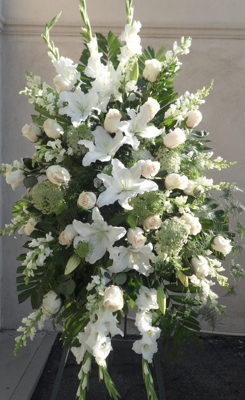 Graceful and elegant, this all-white standing spray is a timeless tribute to