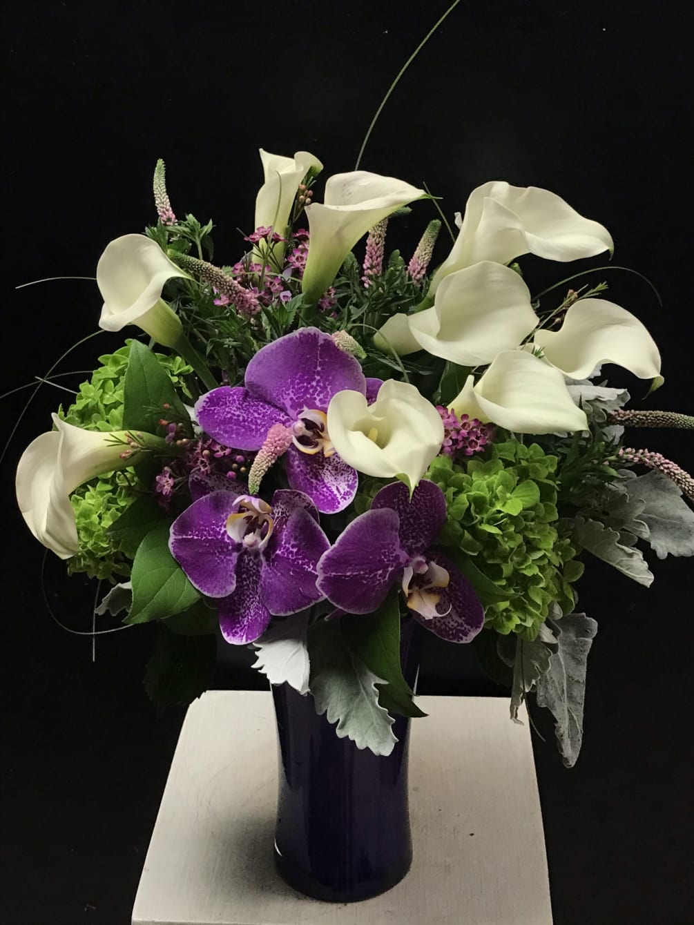 An exquisitely designed arrangement of miniature calla lilies and phalaenopsis orchids. 