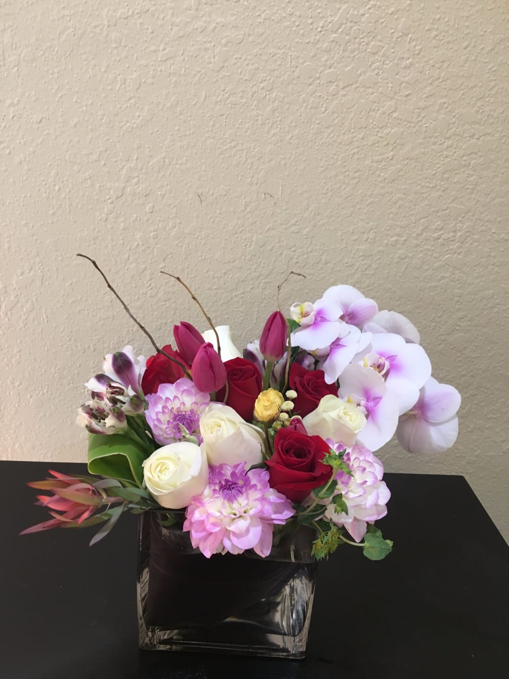 An elegant mix of roses and tulips embraced by beautiful orchids and