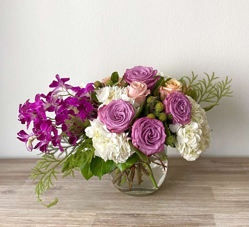 Beautiful flower arrangement with dendrobium orchids, purple roses, Brunia, exotic foliage and