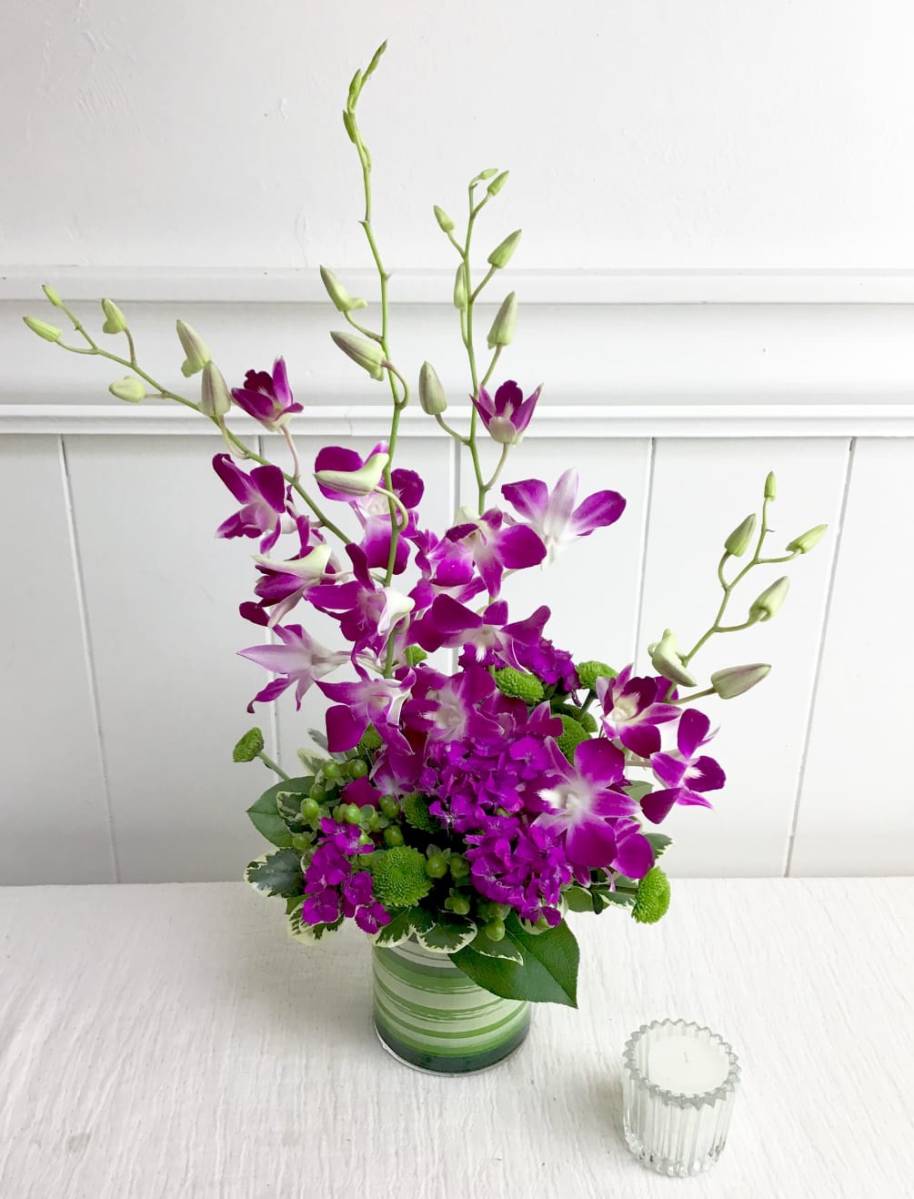 This exotic arrangement is absolutely overflowing with beautiful orchids, bright hypericum berries