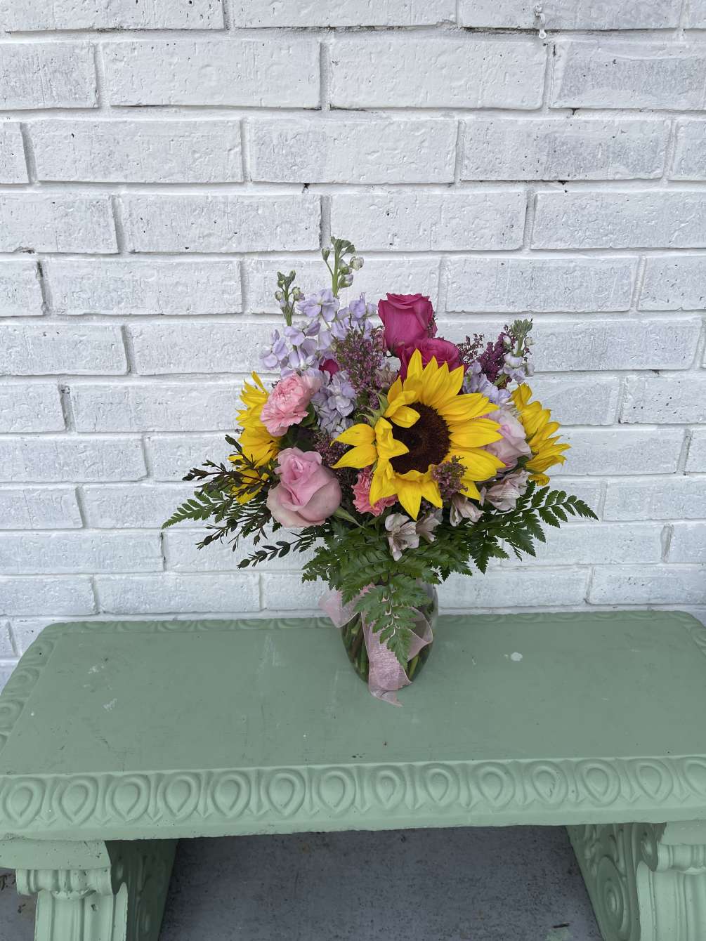 Mixed floral with sunflowers, roses, and a variety of filler flowers paired