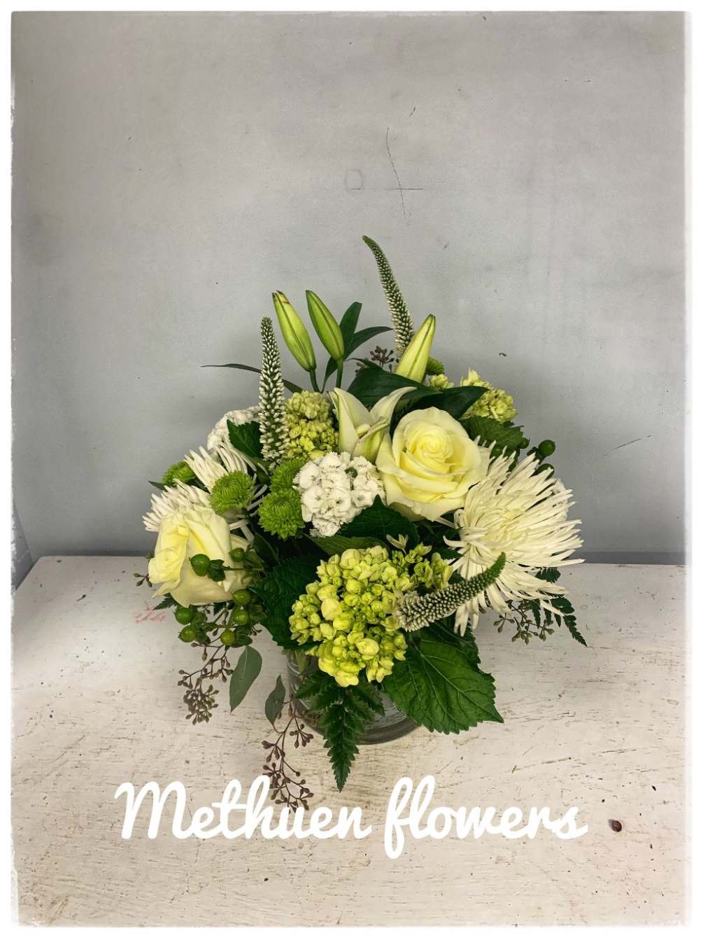 this mid sized arrangement is elegant with all white and green beautiful