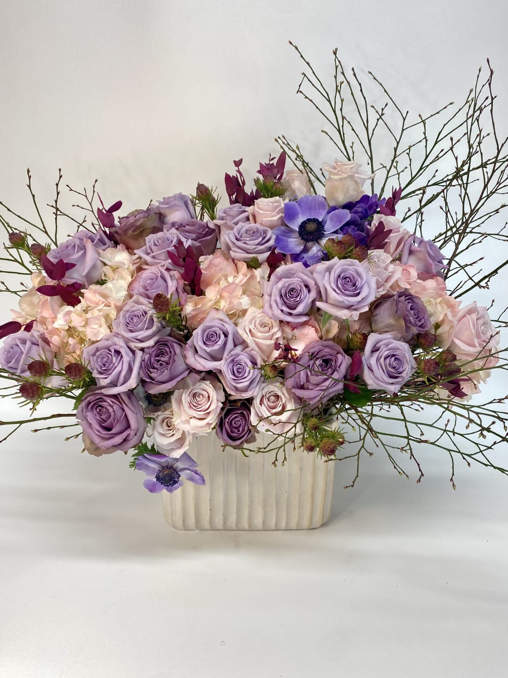 Large, soft, elegant, feminine floral arrangement contains pink hydrangeas, too unique purple