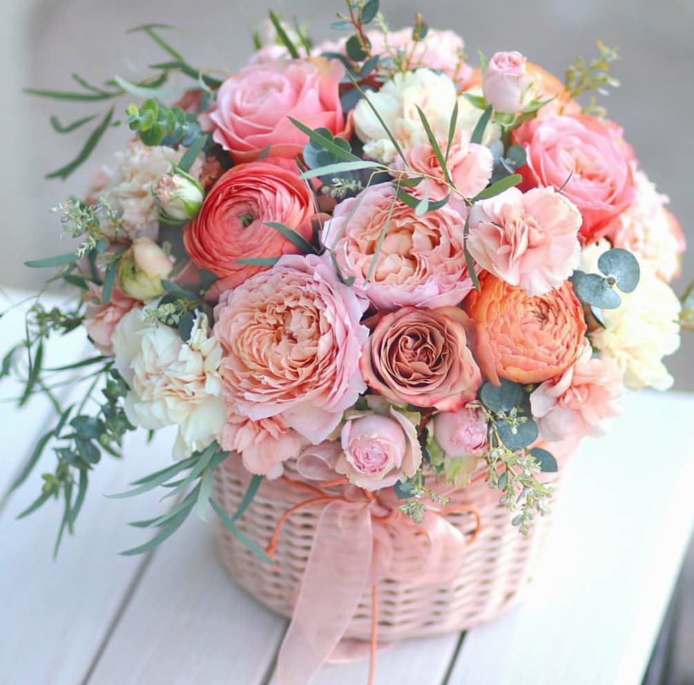 Basket full of organic garden roses, ranunculus, mini carnations, carnations, spray roses