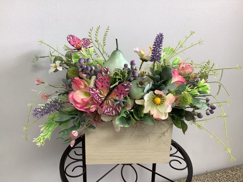 Silk flowers in a wooden box with butterflies