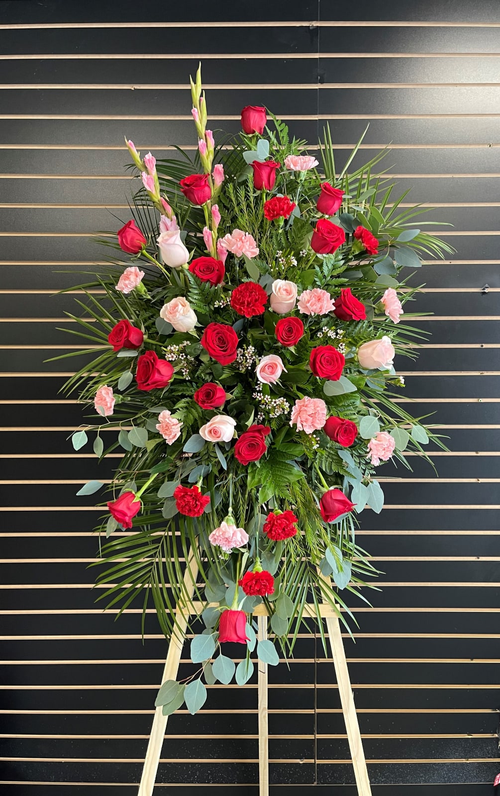 standing spray with mix of pink and red roses and carnations 
green