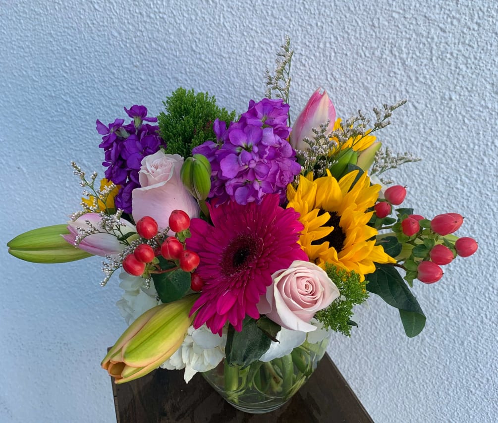 This  arrangement of, gerbera daisies, pink roses, pink lilies, sunflowers, tulips