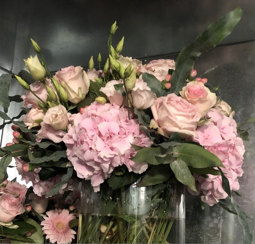 Shades of pink with textured greens in a glass vase