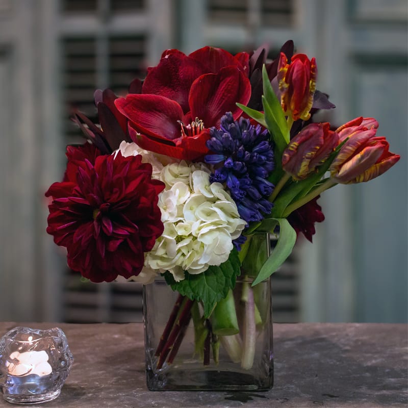 A mix of red amaryllis, parrot tulips with contrasting hydrangea and hyacinth.