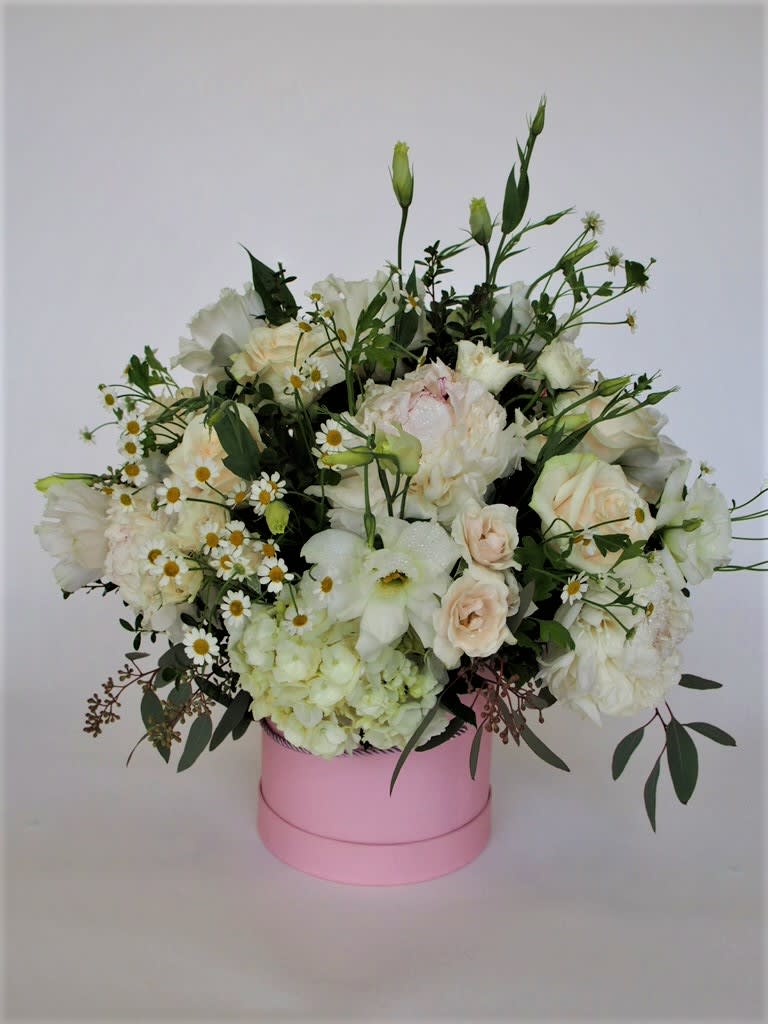 Seasonal mix of white flowers with greens, vase/box according to our availability.