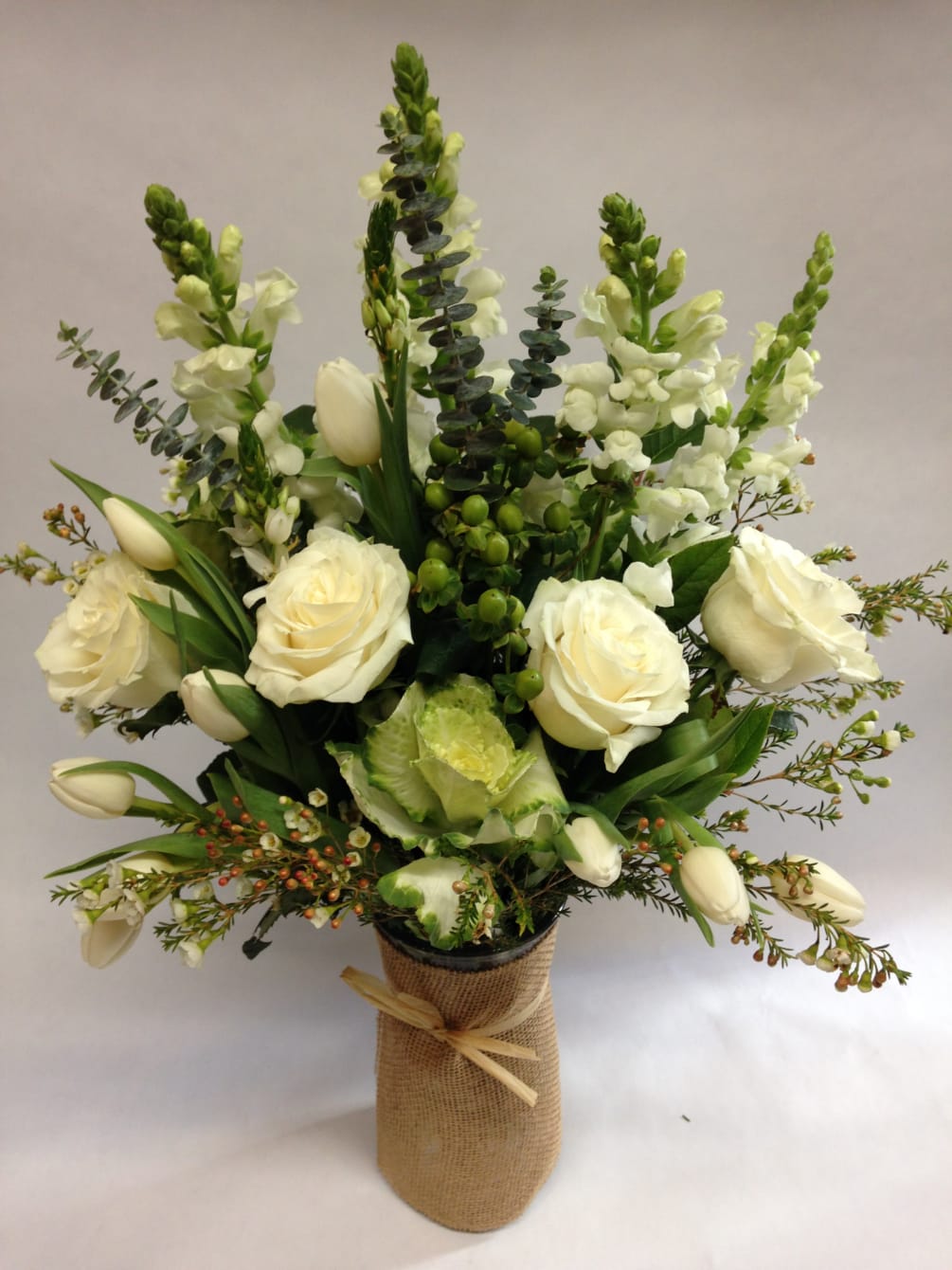 This elegant assembly of green and white flowers comes complete with white