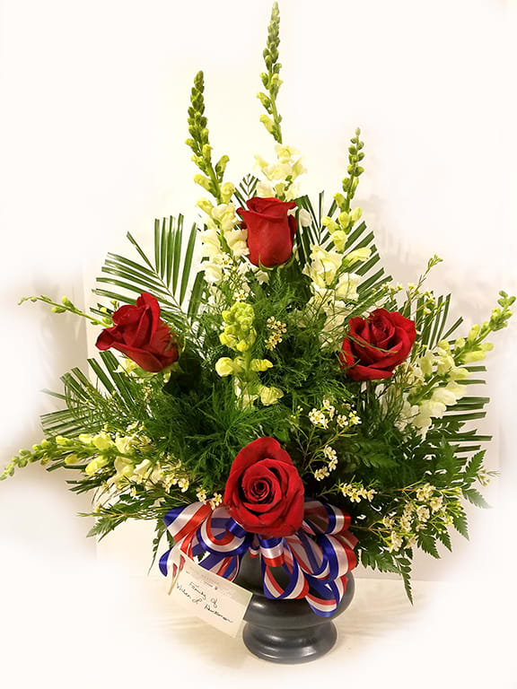 This tribute piece has red roses and white gladiolas with a red