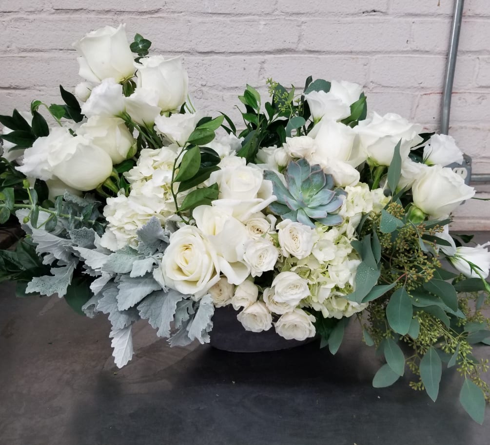 Thoughtful collection of white flowers in a unique container. Express love and