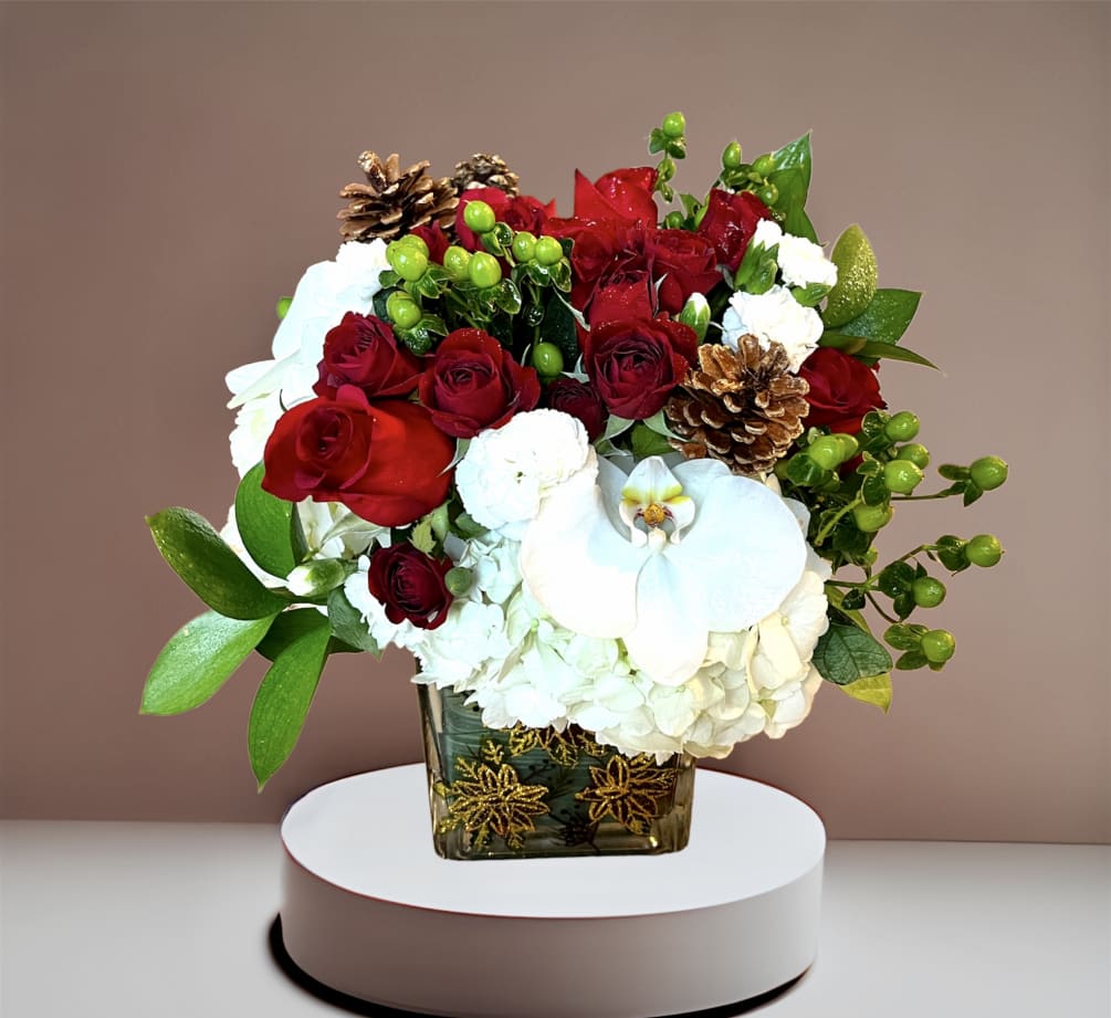A festive holiday mix of roses, hydrangea, berries and pinecones in a