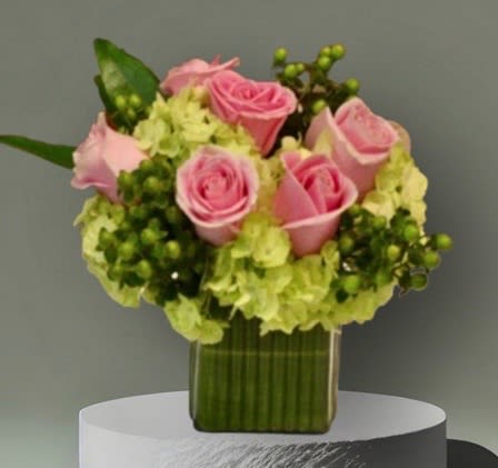 A pretty mix of pink roses, green hydrangea, and green berries in