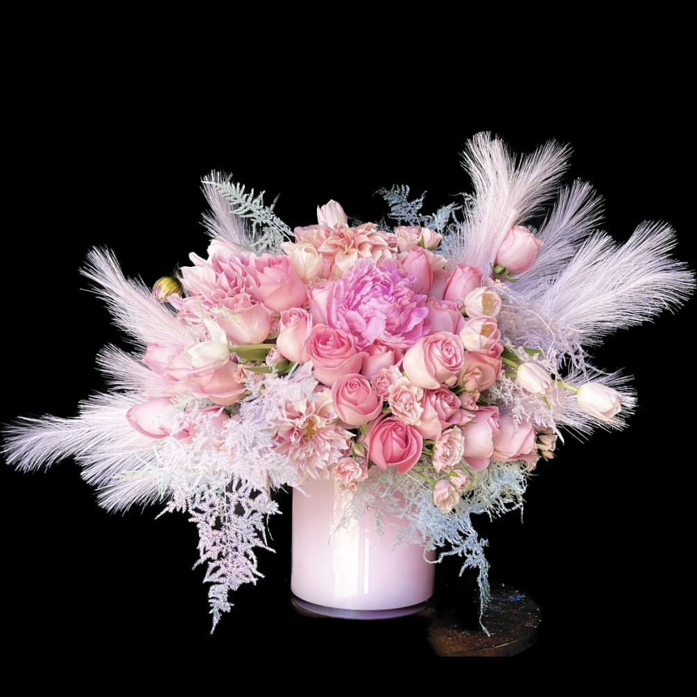 A beautiful, sleek, modern arrangement of pink roses framed with pink feathers